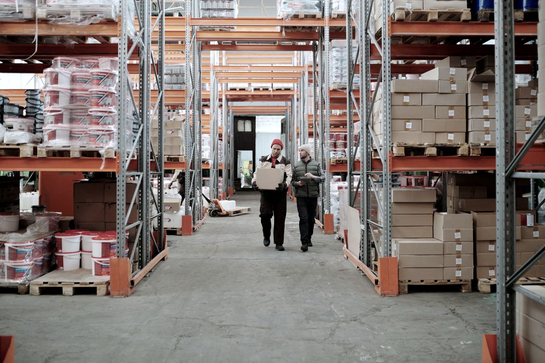 Two people walking down a warehouse aisle