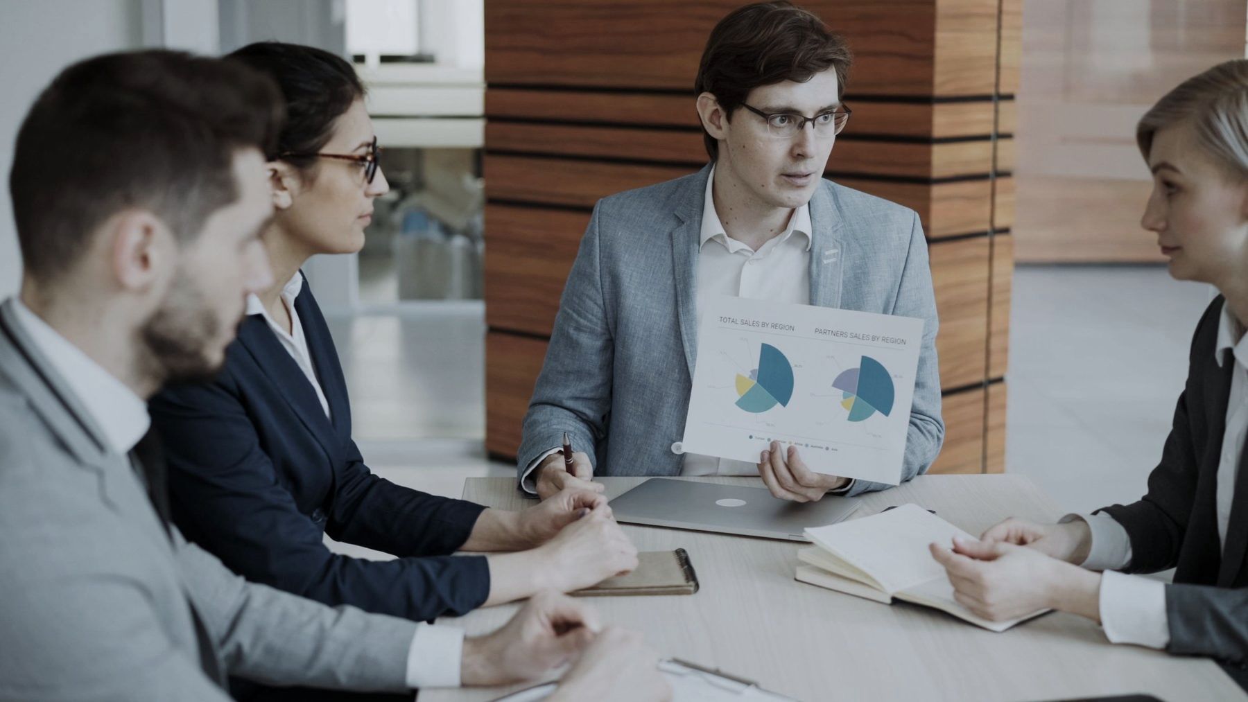 Colleagues presenting a chart at a meeting table