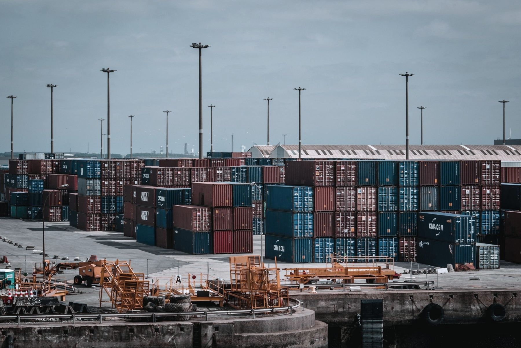 A container port with stacked shipping containers and cranes