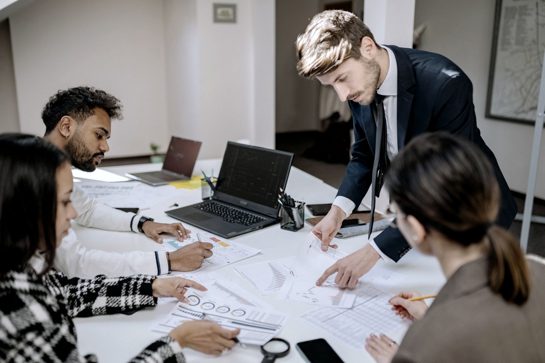 Colleagues working over printed plans at a table